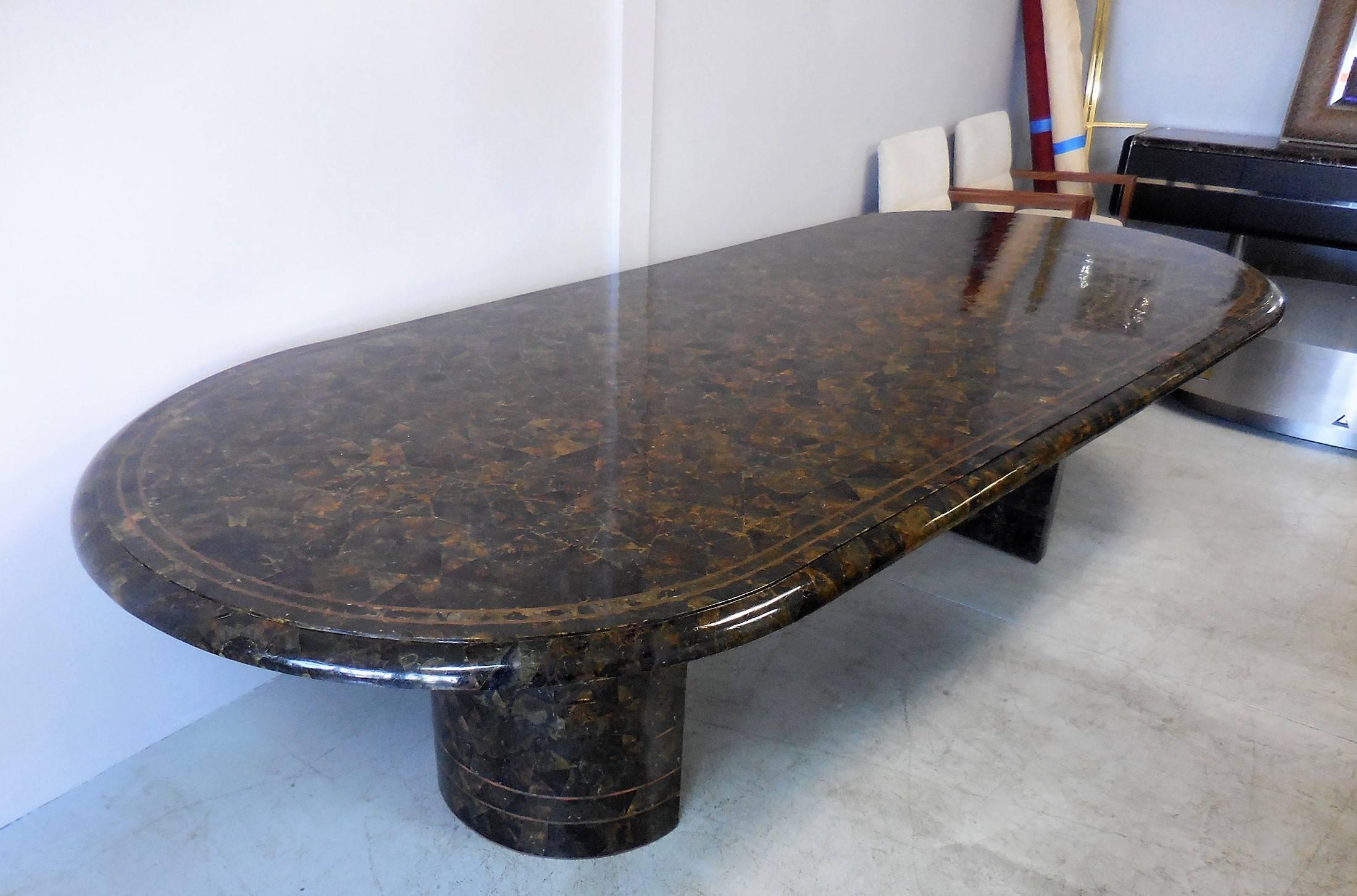 Extraordinary dinning or conference table by Maitland-Smith. It's all done in Penn Shell with brass inlay, spectacular look that's reminiscent of turtle shell. The two radial bases are also done in the same material. Table is in excellent condition