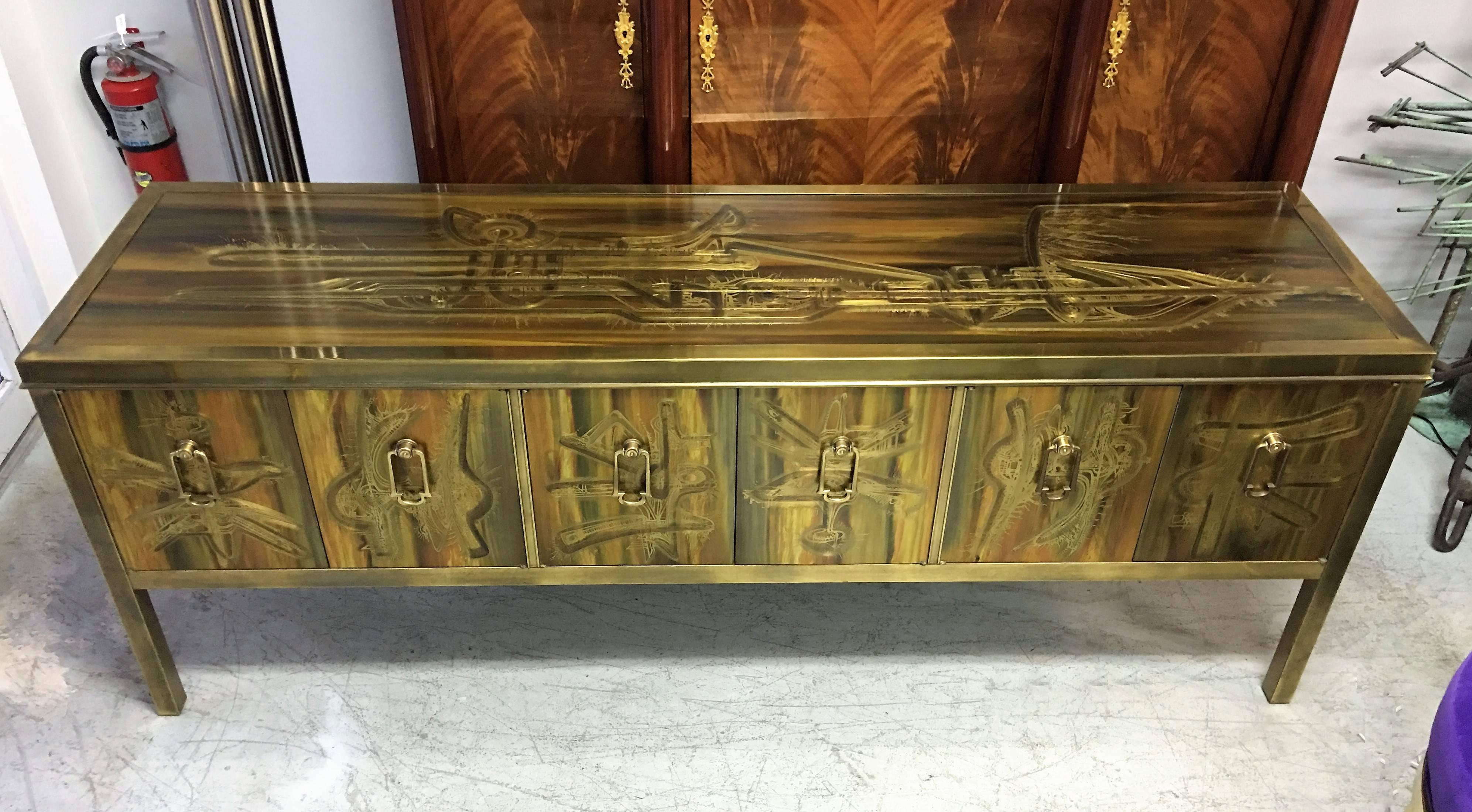 Stunning sideboard or credenza by Mastercraft, featuring the fantastic acid etched designs by Bernhard Rohne. Large brass pulls used to open six doors that reveal ample storage space.
