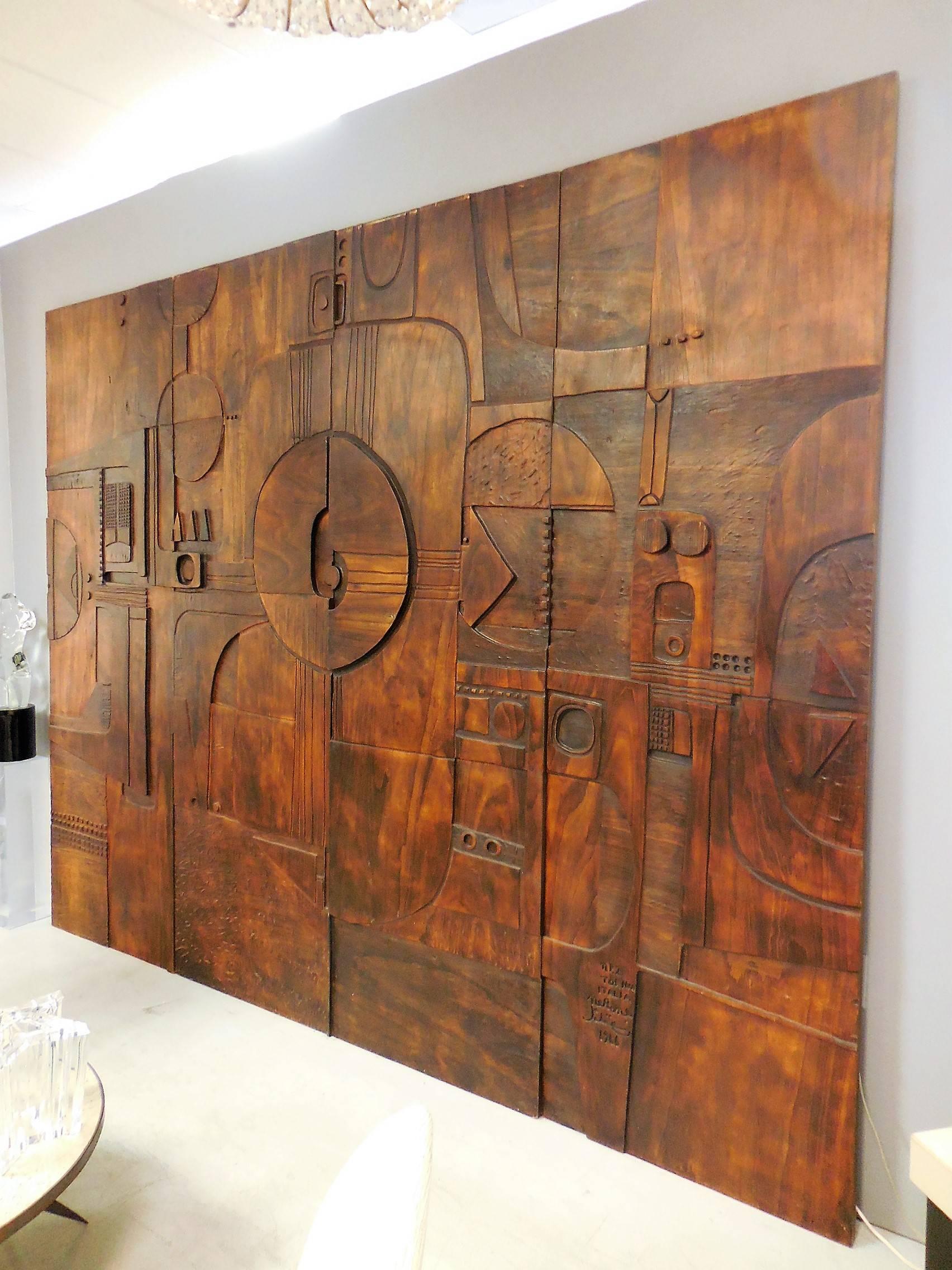 This is a monumental sculptural wall panels by Nerone and Patuzzi, Gruppo NP2. Comprised of four carved panels with modernist symbolic decoration that create a visual feast for the viewer. The carving is masterful with passages done in pyrography