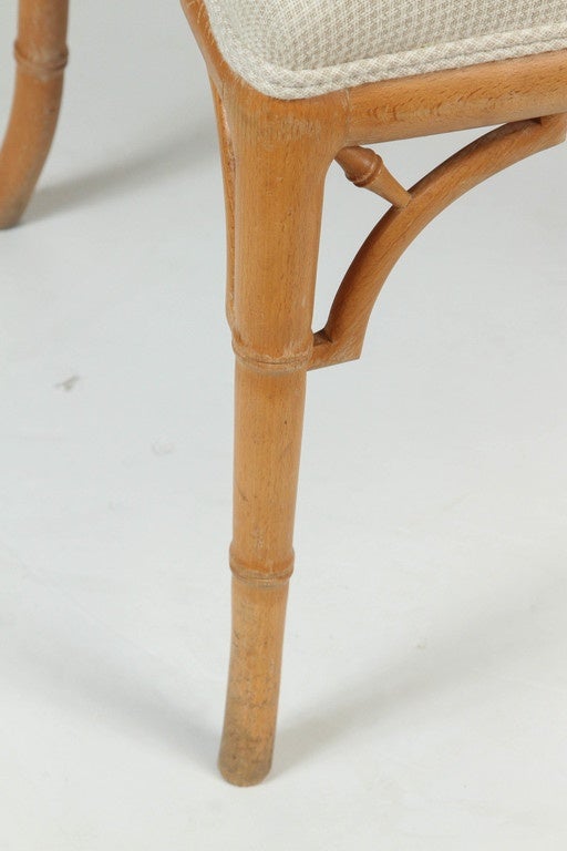 Wood Chinese Chippendale style faux bamboo chair featuring natural wood and a white upholstered seat.