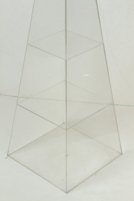 Mid-Century Modern Lucite pyramid display unit with four shelves for decorative goods.