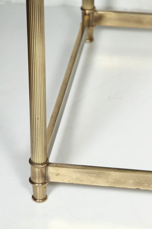 Brass coffee table with glass top. Rectangular in shape with heightened curved edges.