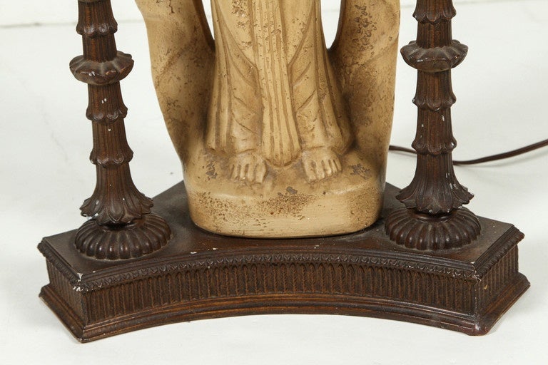 Pair of Mid-Century lamps with a statue base of a 19th Century mythological lady, centered inside intricate wood pillars.