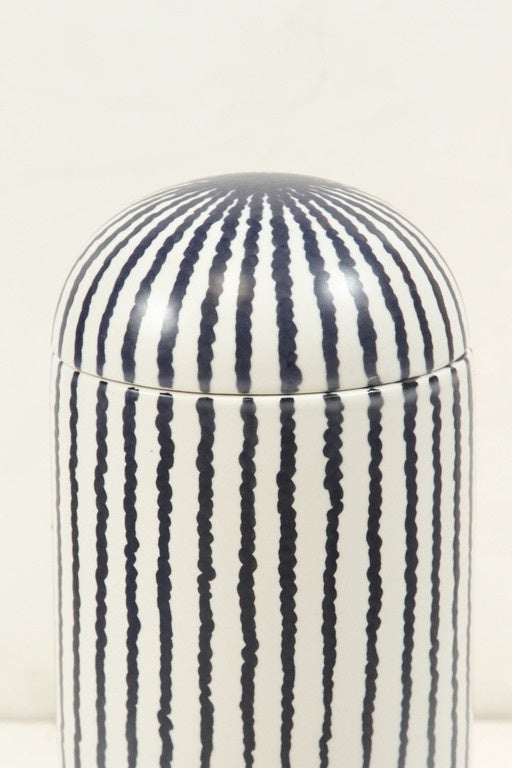 White ceramic vase with navy blue vertical organic stripes and a carved face motif, this vase is part of a Bosa collection that pays a timeless tribute to women of all cultures.