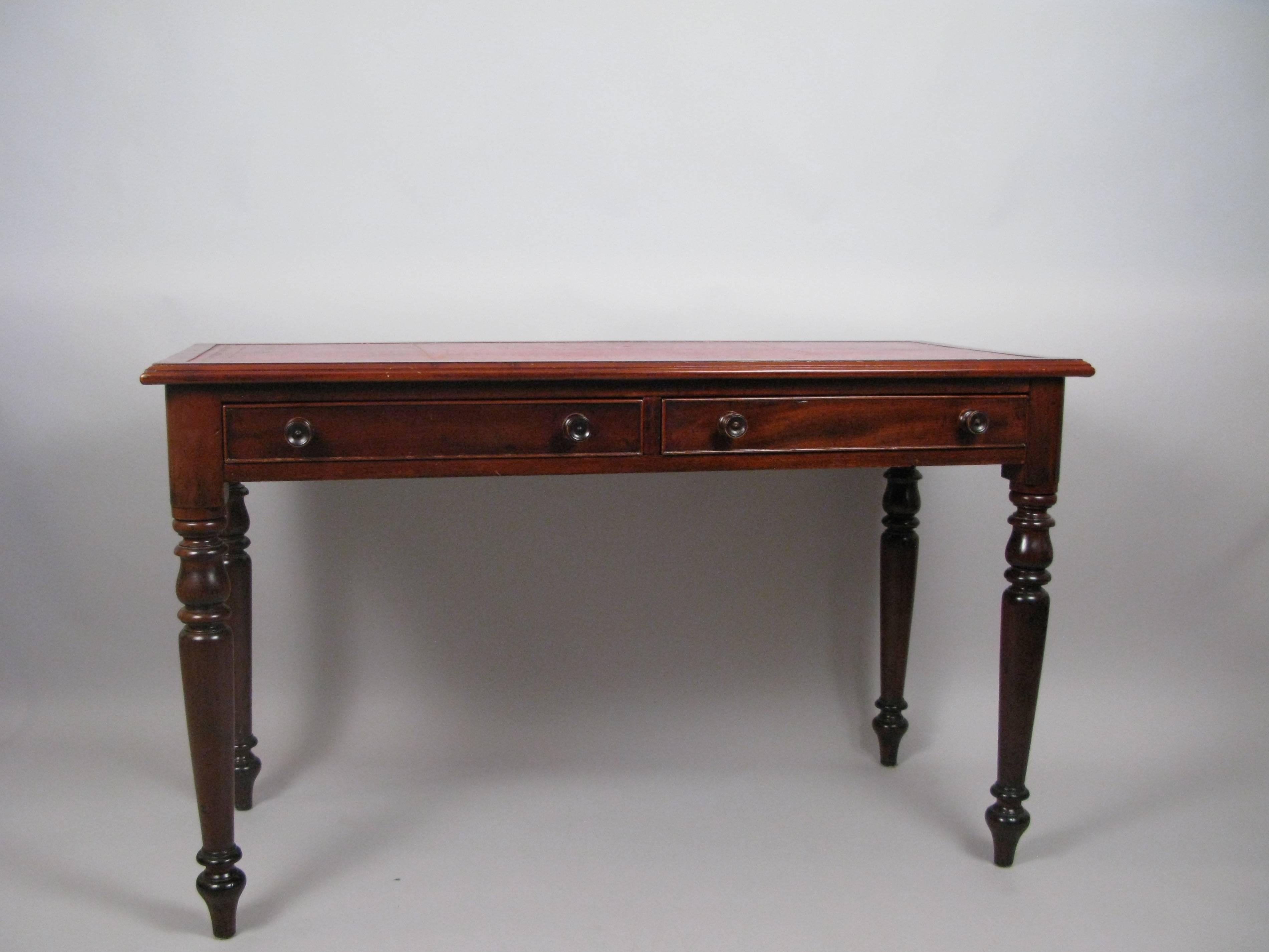 Handsome and useful writing desk. A good, compact size for computer work with surface and drawer space. English, mid-19th century and understated, but elegant, turned legs.