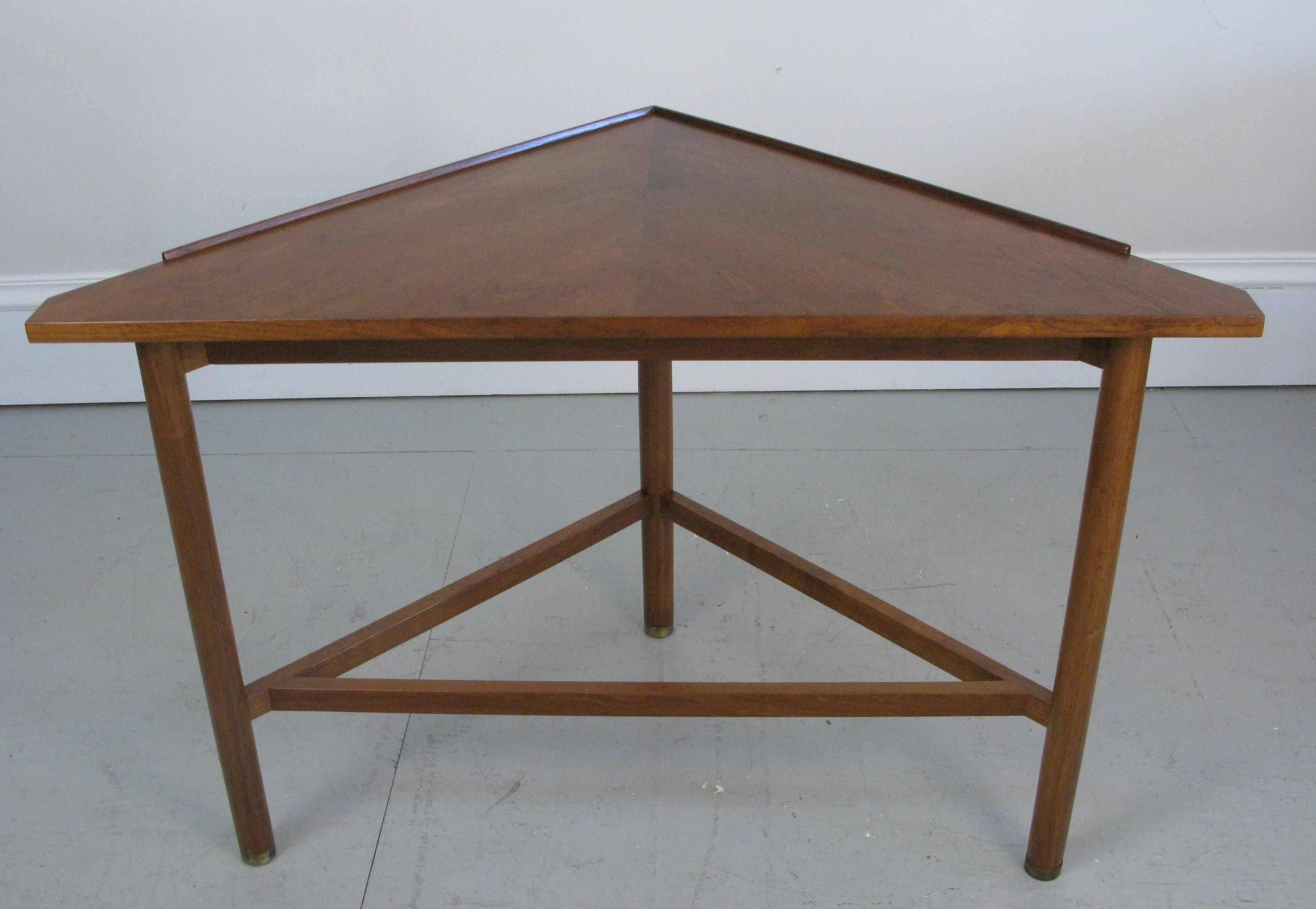A 1950s well thought out geometric triangle console table by Edward Wormley for Dunbar. Raised edge and beautiful walnut. Ended in brass footing. Table has been newly finished.