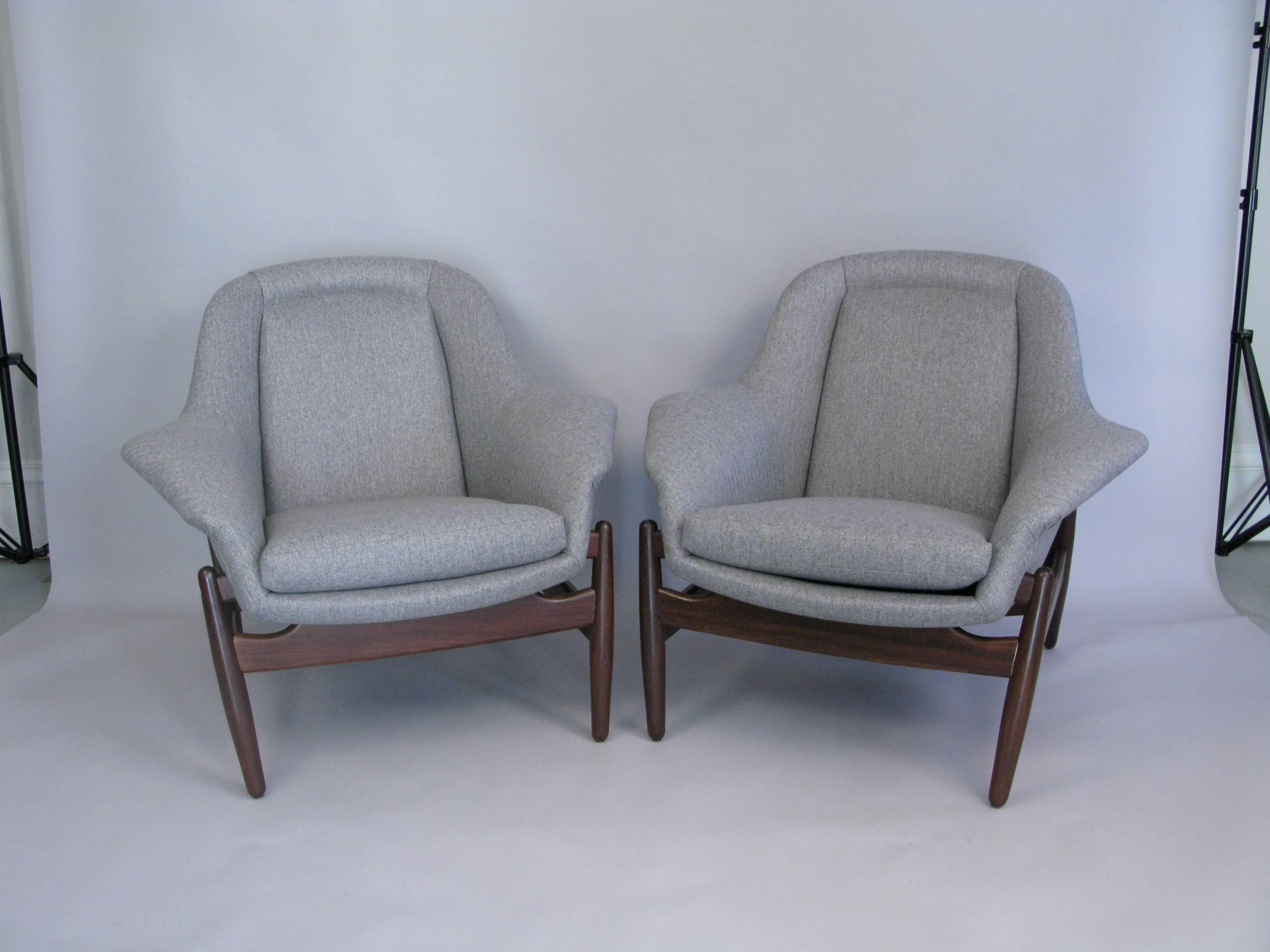 A fine pair of Danish 1960s walnut framed lounge chairs with a George Tanier selection label. Excellent design and comfort. New upholstery and finish.