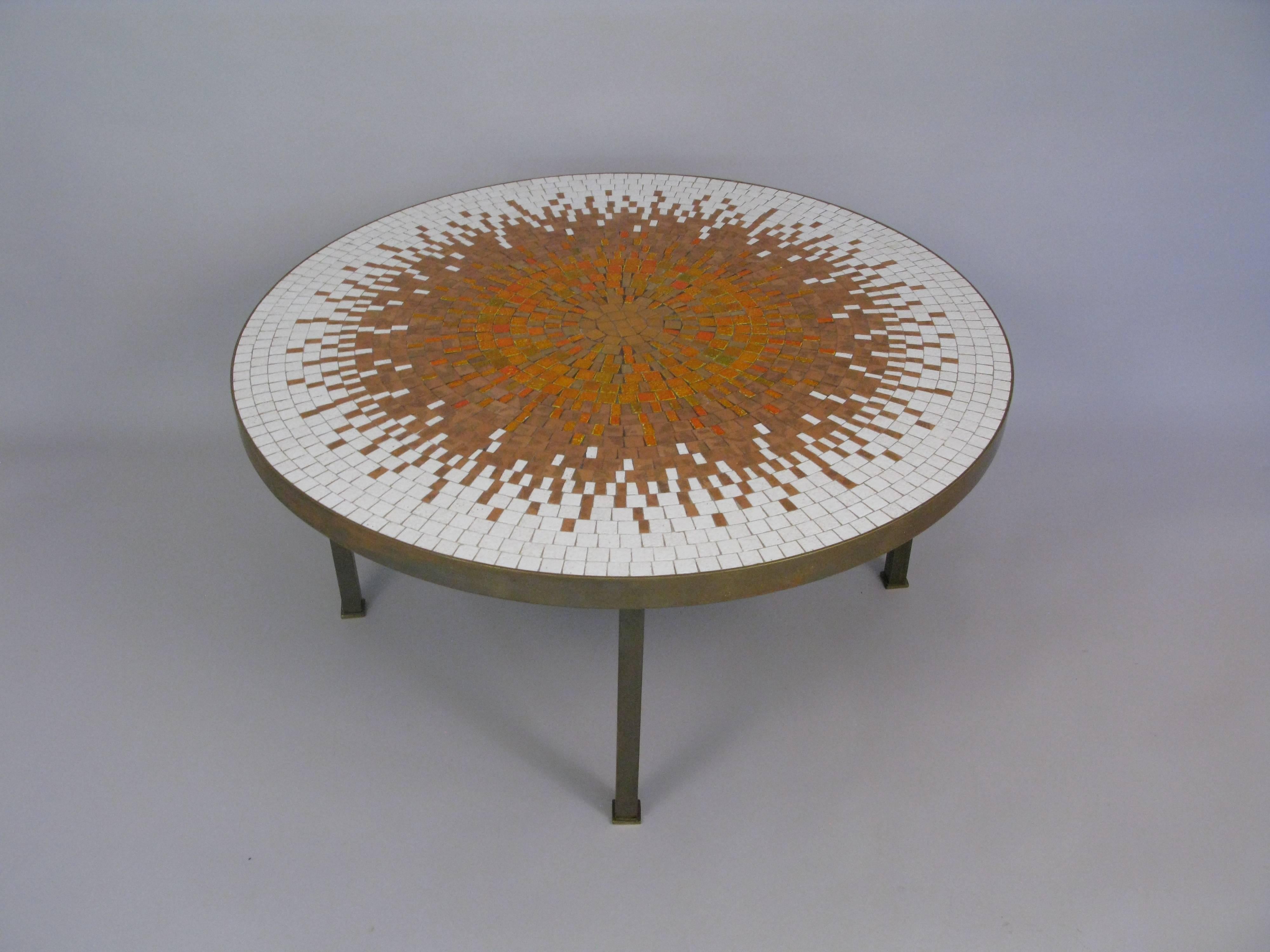 Good looking 1960s-70s Mosaic top and brass based coffee table. The tiles are set in wonderful sunburst pattern and are in excellent condition.  There is discoloration to the brass.  36 inch 