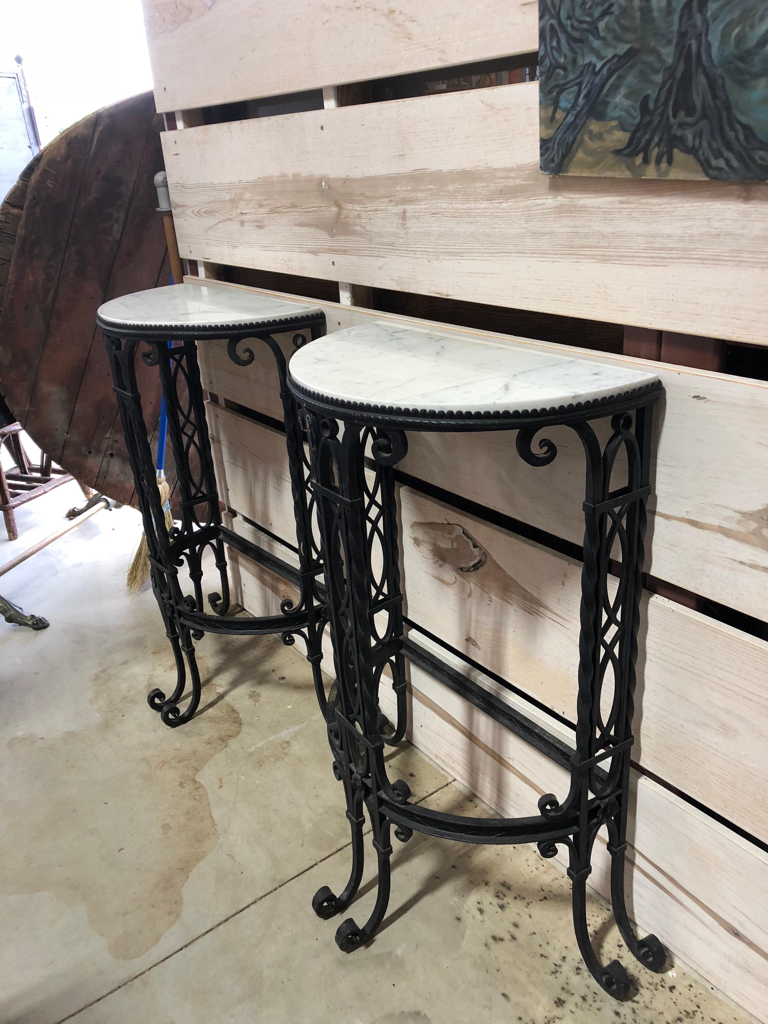 Antique French demilune iron tables with Carrara marble tops.