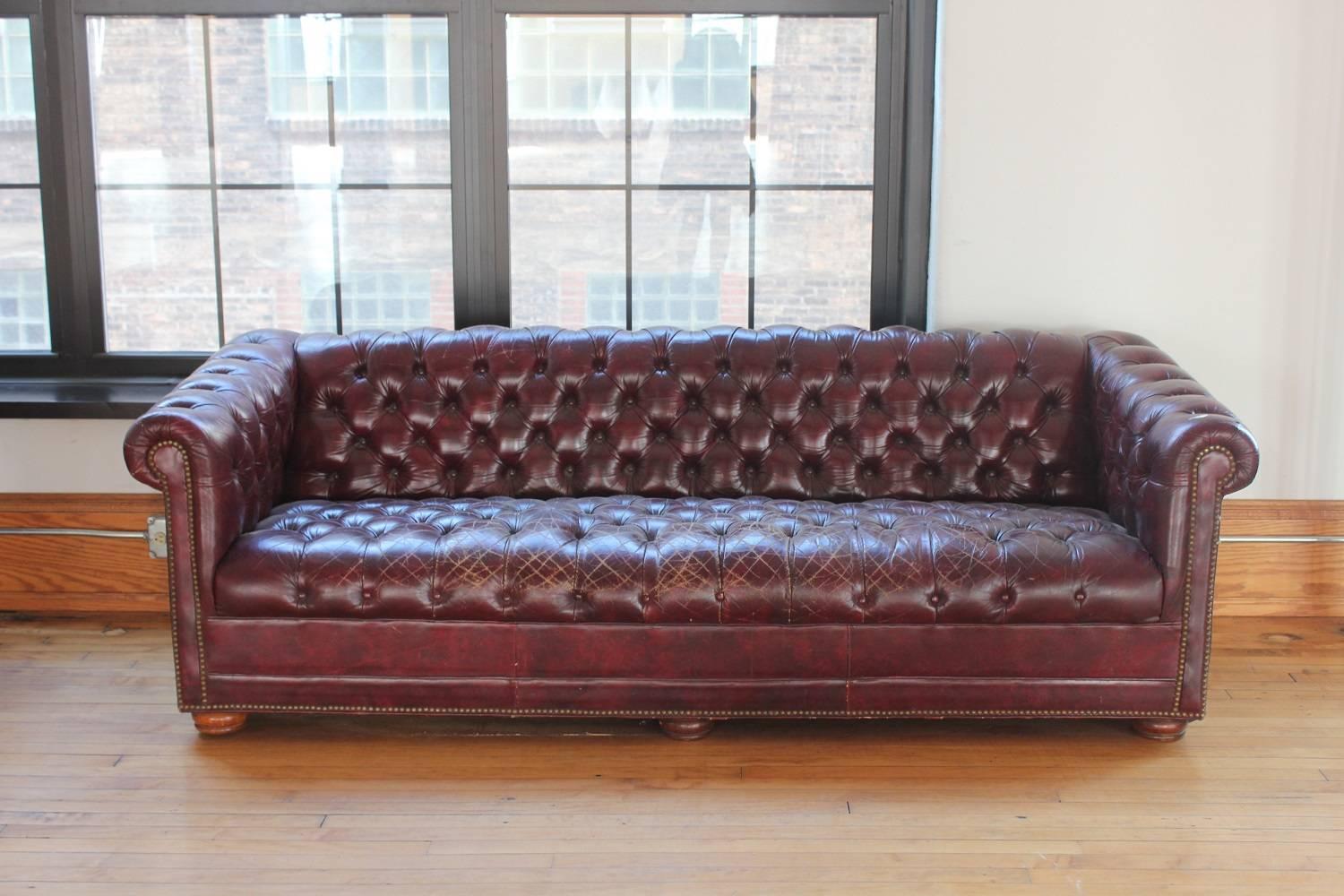 Vintage distressed burgundy leather Chesterfield sofa.