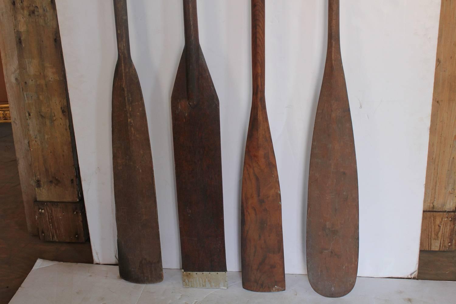 Collection of four antique wooden oars.