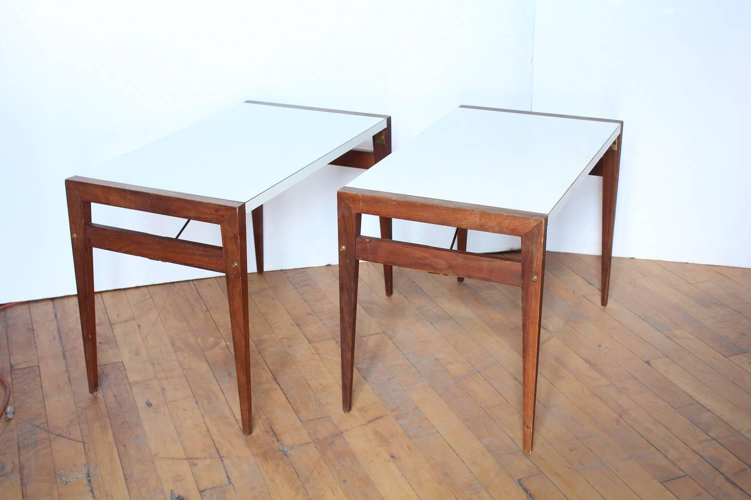 Mid-Century walnut side tables by John Keal for Brown Saltman with brass hardware and white Micarta tops. Legs are folding.