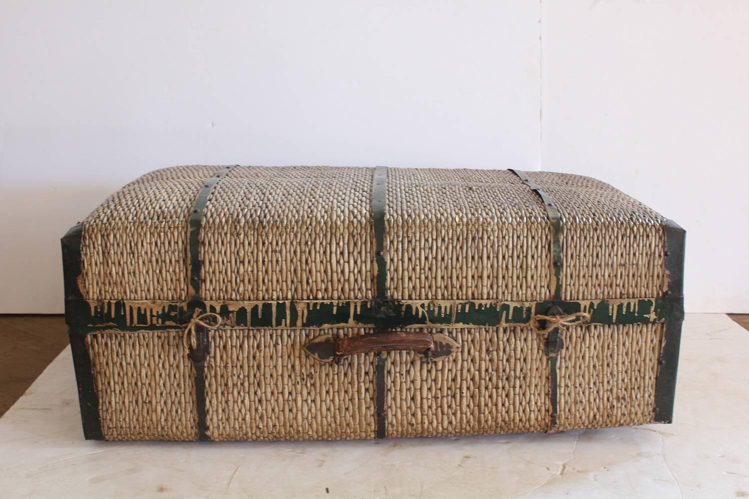 Large antique straw and metal suitcase.