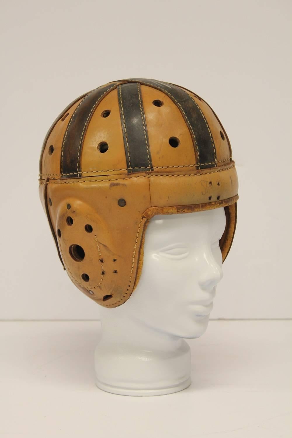 Antique Spalding football leather helmet with glass hat form.