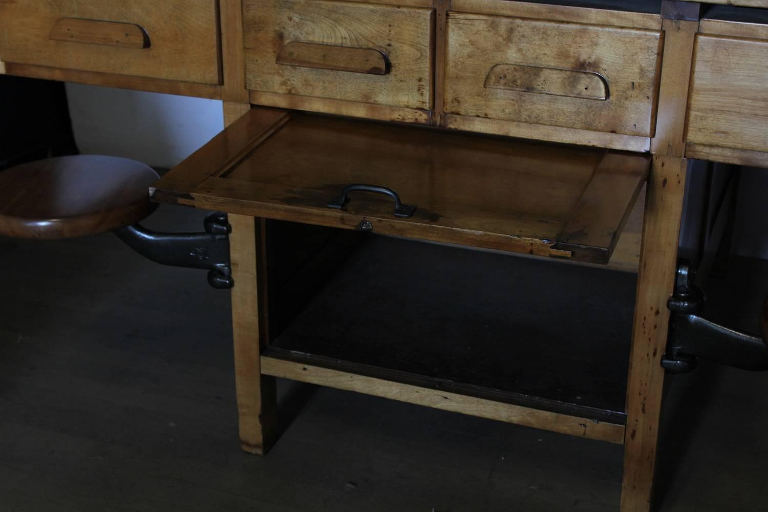 1920s American double sided science laboratory table with swivel stools.