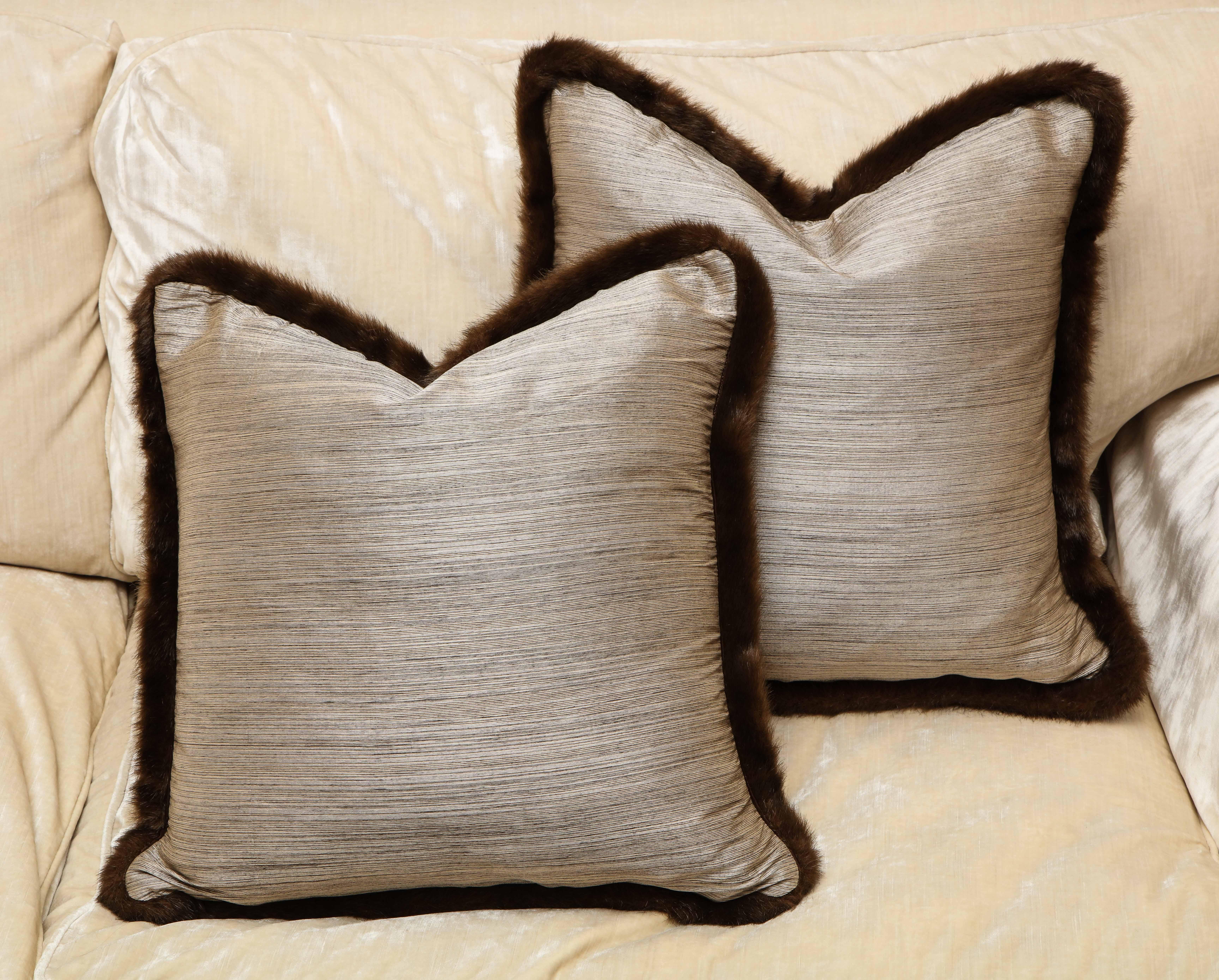 Chic and one of kind pair of silk and fur pillows. Silver and bronze textile with chestnut fur. The textile has Japanese English provenance from England, early 20th century. And the European fur around exudes Anglo-Japanese style. The pillow is
