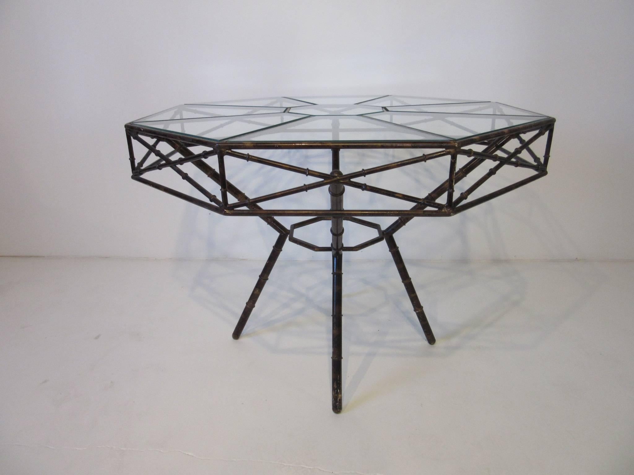 A faux tortoise shell metal table in the style of bamboo with nine separate areas of cut-glass to the top forming a octagon pattern. This work runs throughout the table making it a one of a kind piece for that entry way or dining area.