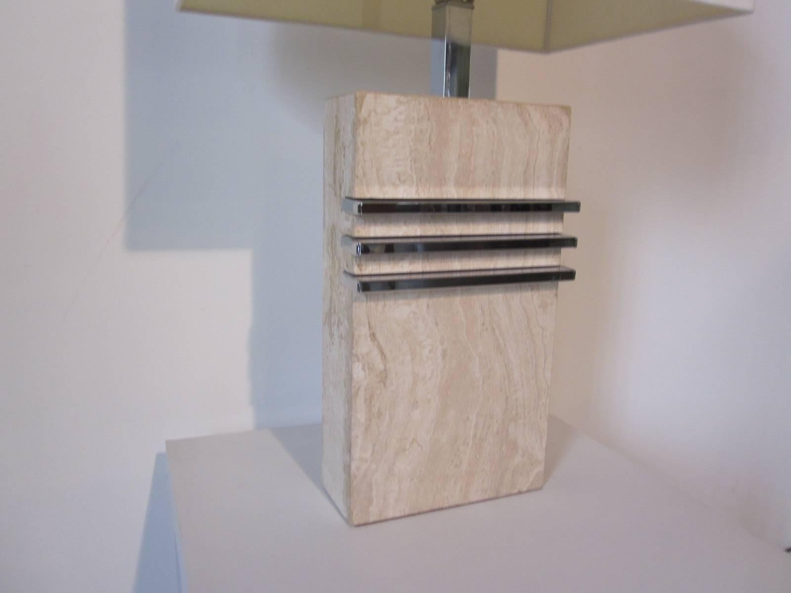 A Karl Springer styled marble based table lamp in a creamy beige off white with chrome strips and neck topped by a linen box shade.