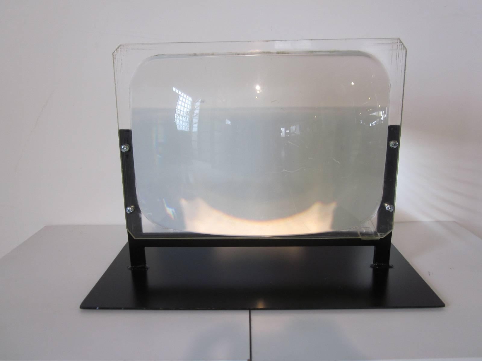 A vintage cast resin/ Lucite and liquid magnifier viewer mounted on an Industrial styled steel base. These were used in the late 1940s and early 1950s to increase the size of a TV screen when technology limited the size of a picture tube. The