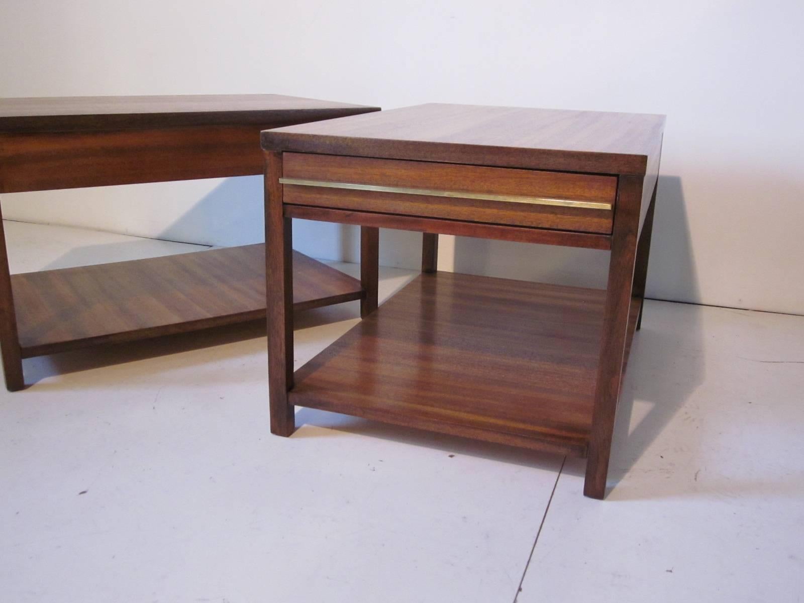 Well grained Indonesian mahogany end tables or nightstands with lower shelve area and one drawer with long thin brass pulls, manufactured by The American of Martinsville Furniture Company.