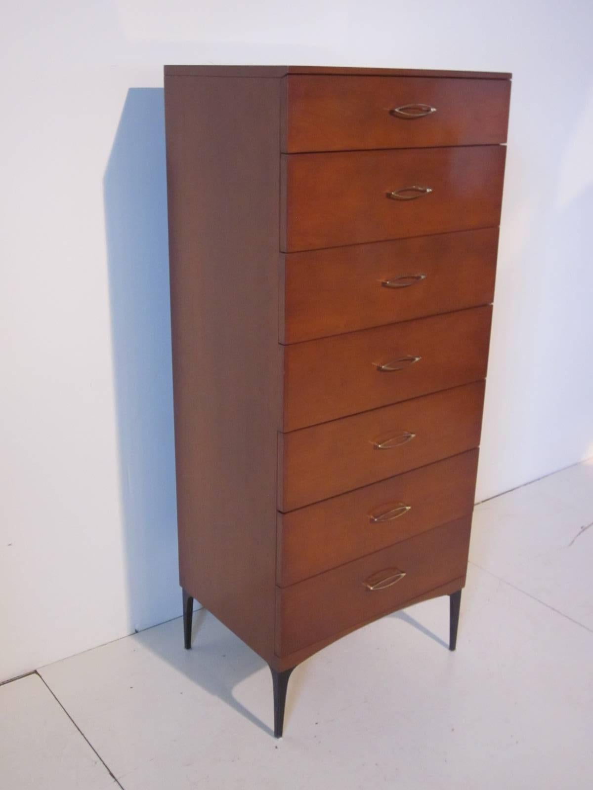 A seven-drawer mahogany tall lingerie or gentleman's chest with very simple elliptical brass handles sitting on tapered black legs. Retains the manufactures label to the top drawer Heywood-Wakefield Contessa Line of 1959, a rare and well designed