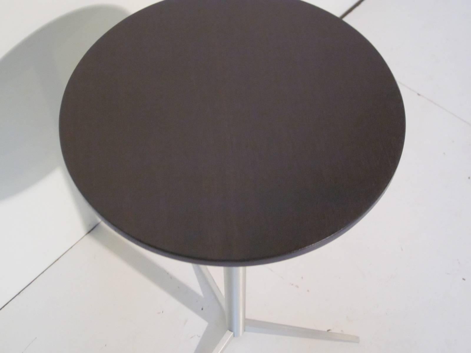 A ebony finished walnut and brushed aluminum tri-pod based cigarette table or side table in the manner of Paul McCobb.