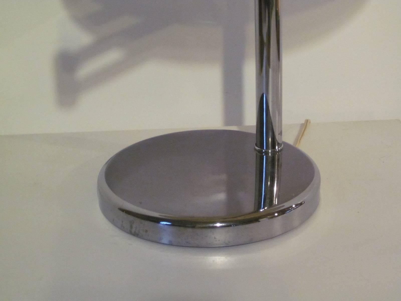 A chromed table / desk lamp with adjustable swing arm and topped with a linen shade manufactured by the Nessen Lighting Company NY. The base of the shade diameter is 14
