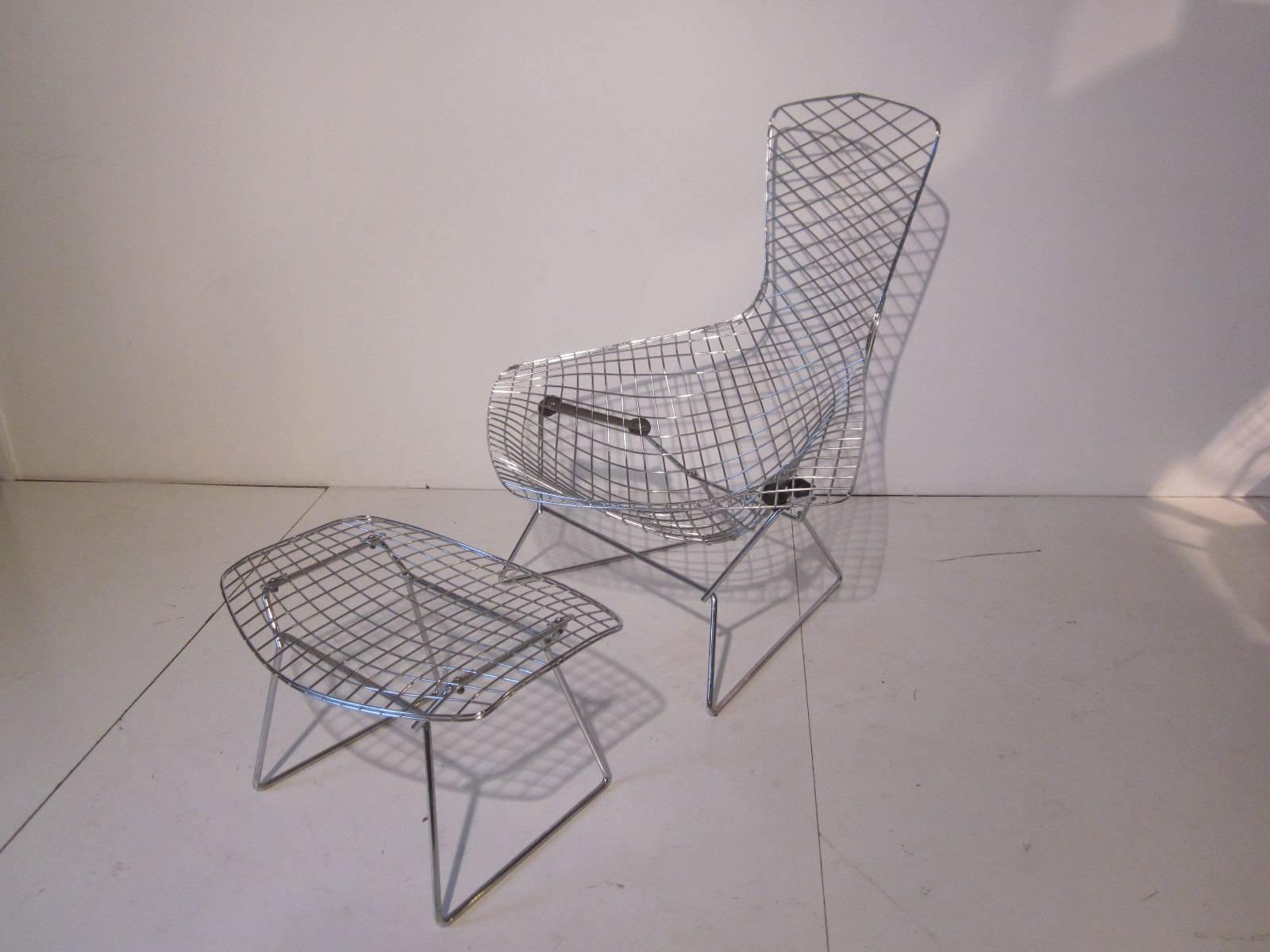 A Harry Bertoia designed bird chair with matching ottoman in chrome steel wire and large rubber shock mounts for comfort, called the bird chair because of it's wing armrest and for it's seat in the style of a birds nest. An iconic design