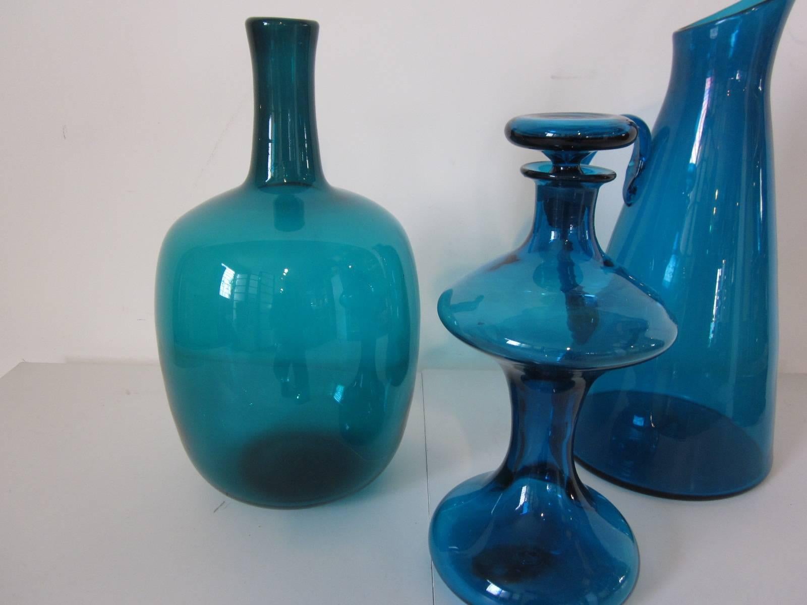 A three-piece collection of handblown blue and blue green Blenko Glass consisting of large pitcher 17.50