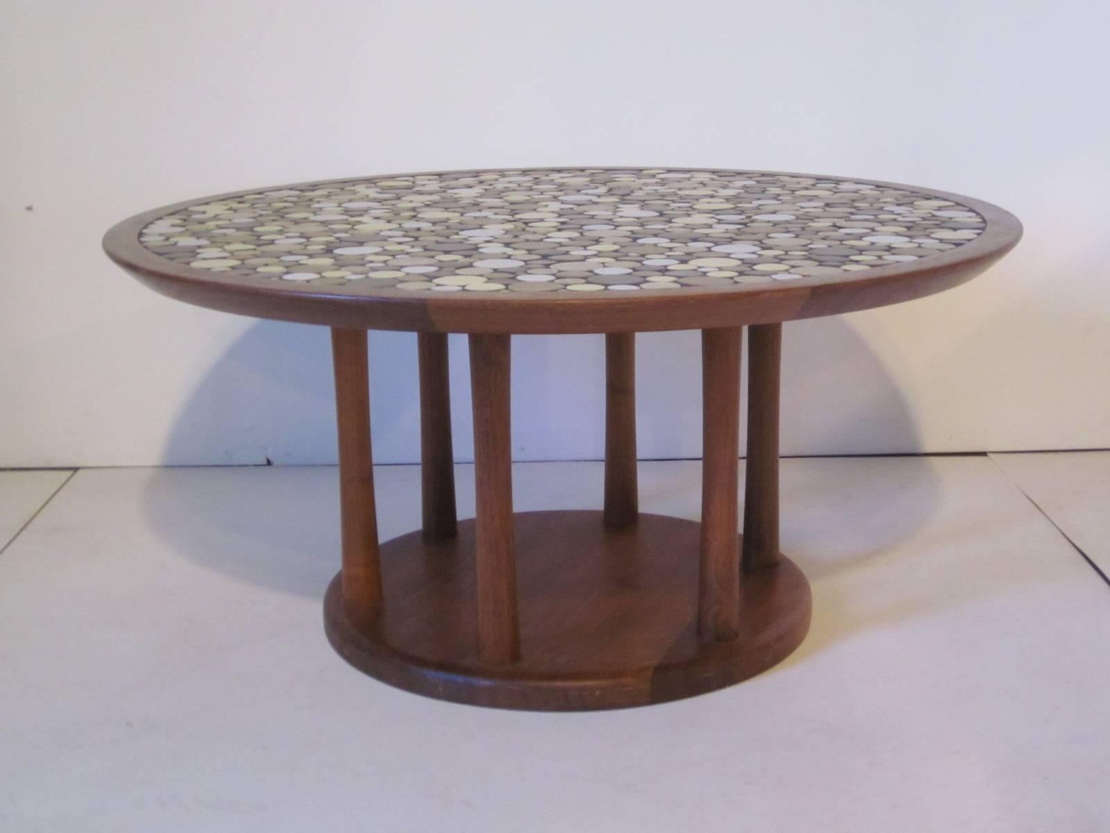 A teakwood based coffee table with Jane and Gordon Martz pottery roundel tile top in nice mellow very light creamy yellow, taupe's, sand and light brown tones. A simple and natural looking furniture design manufactured by Marshall Studios.