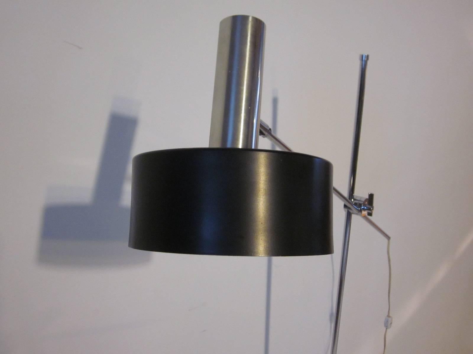A chrome and satin black Italian styled floor lamp with adjustable height and reach of the shade and pivoting head, in the manner of Maria Pergay and manufactured by the Lightolier company.