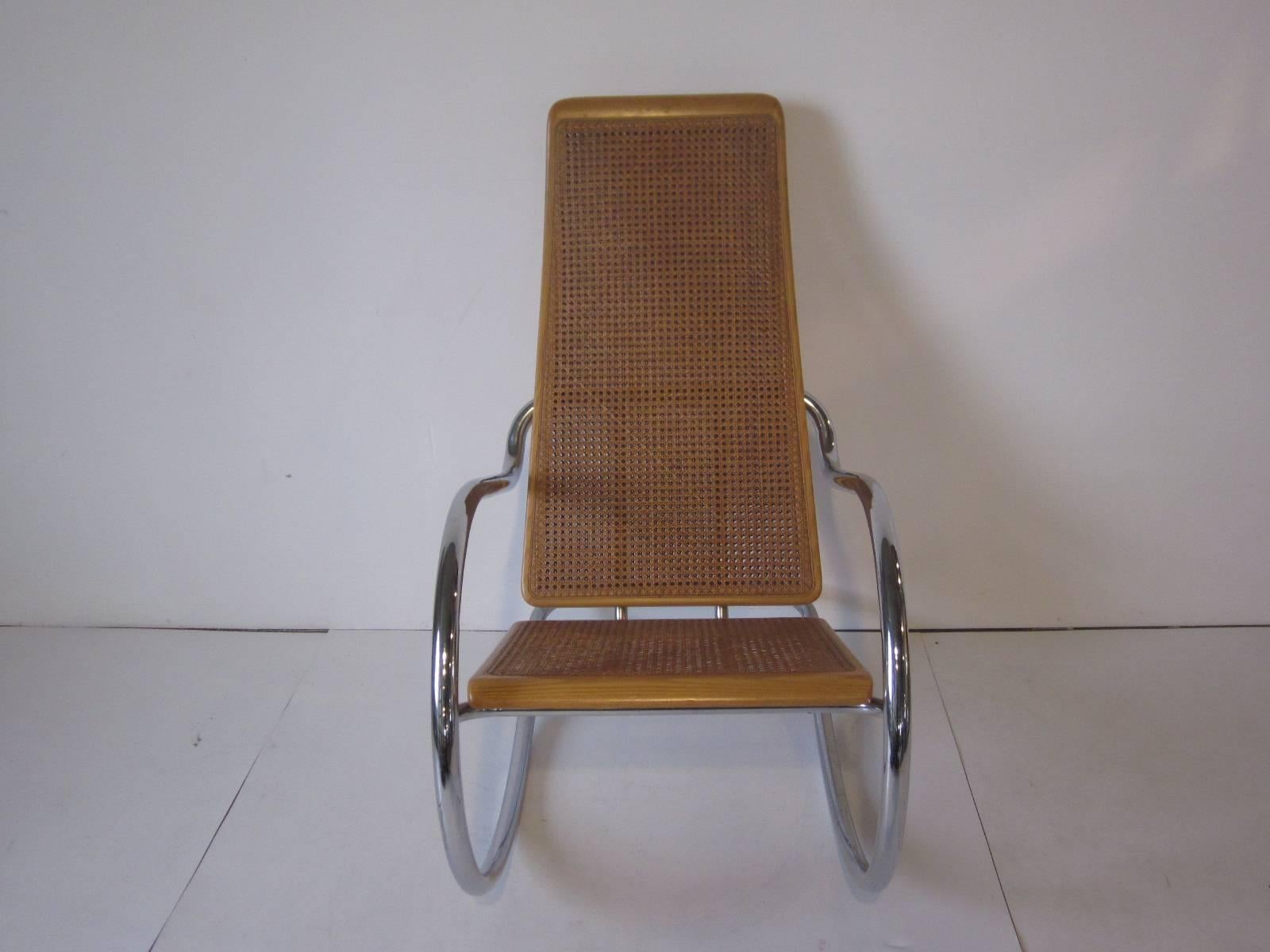 A tubular chrome framed Italian rocking chair with wood frame, double caned seat back and caned bottom retaining the label 