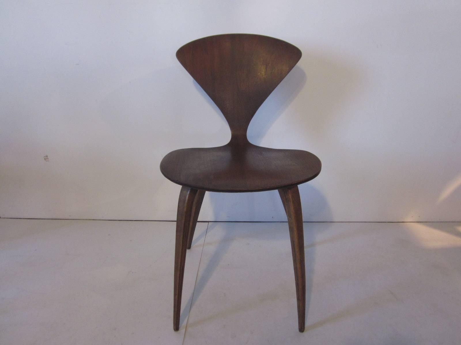 A set of four sculptural wood hourglass shaped side chairs manufactured by Plycraft, retains faded labels to the bottom.