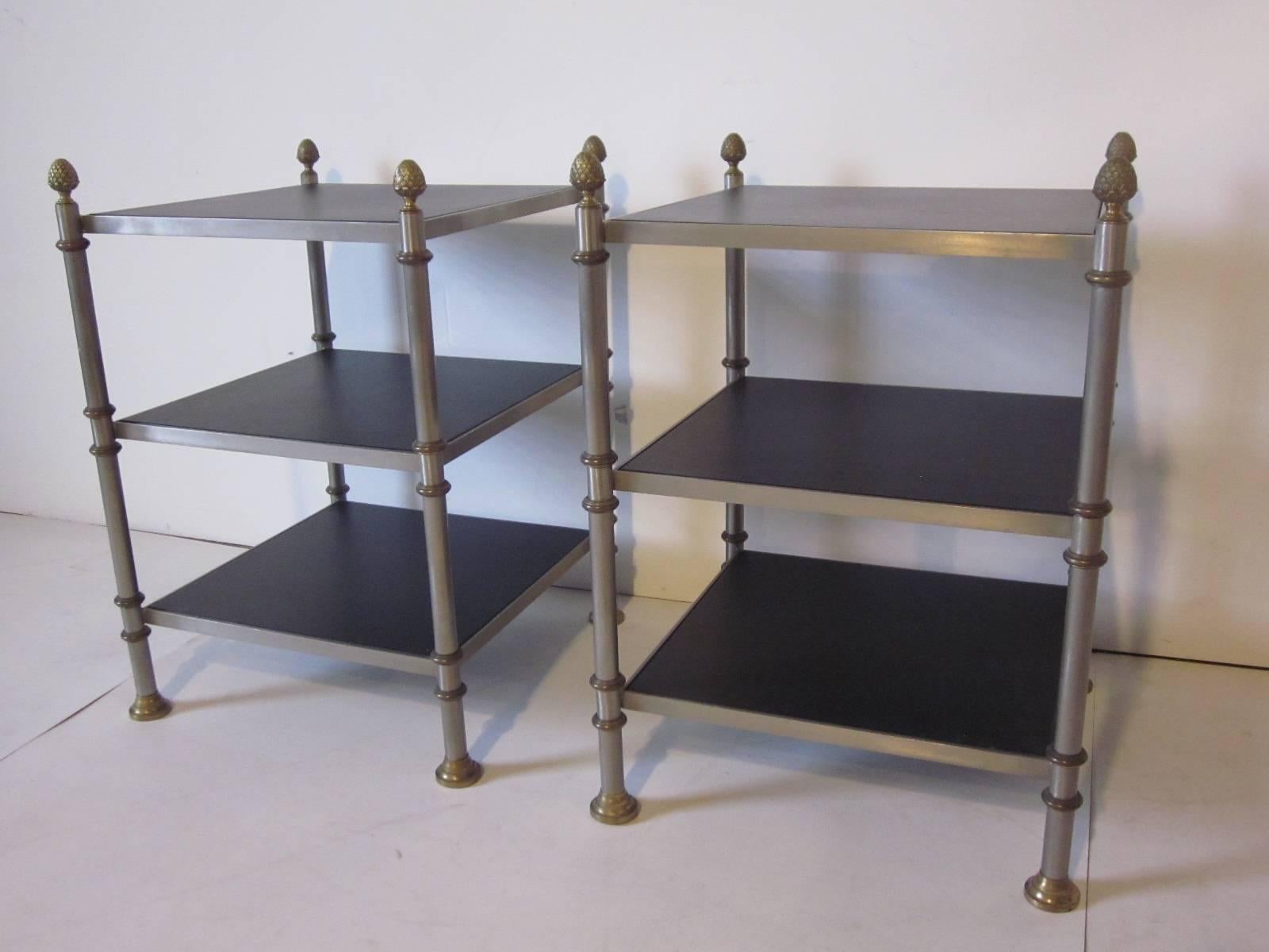 A pair of steel and brass nightstands or end tables with three leatherette covered wood shelves after Maison Jansen and marked made in Italy.
