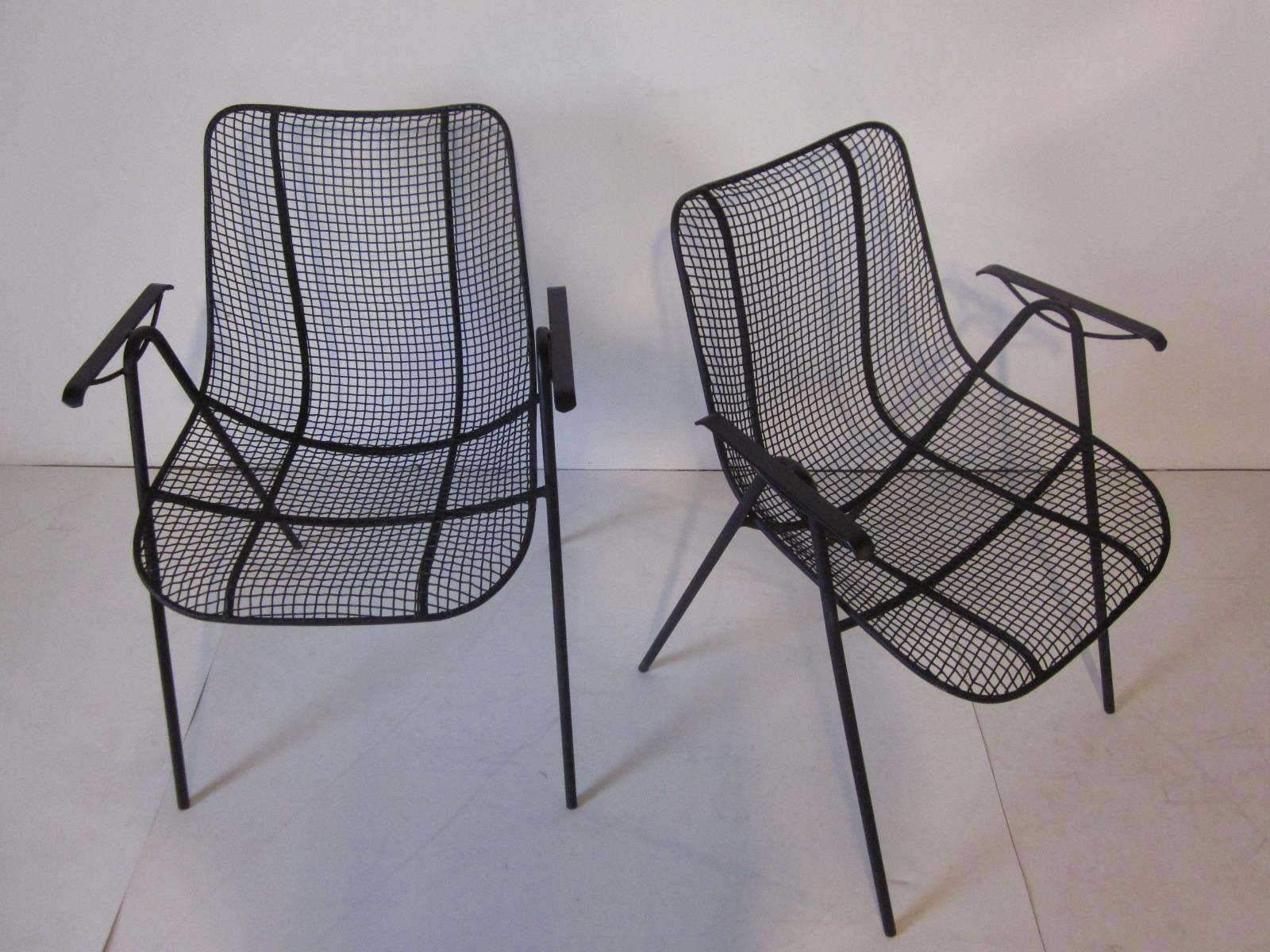 A pair of iron and mesh armchairs, a hard to find style from the Russell Woodard Furniture Company.