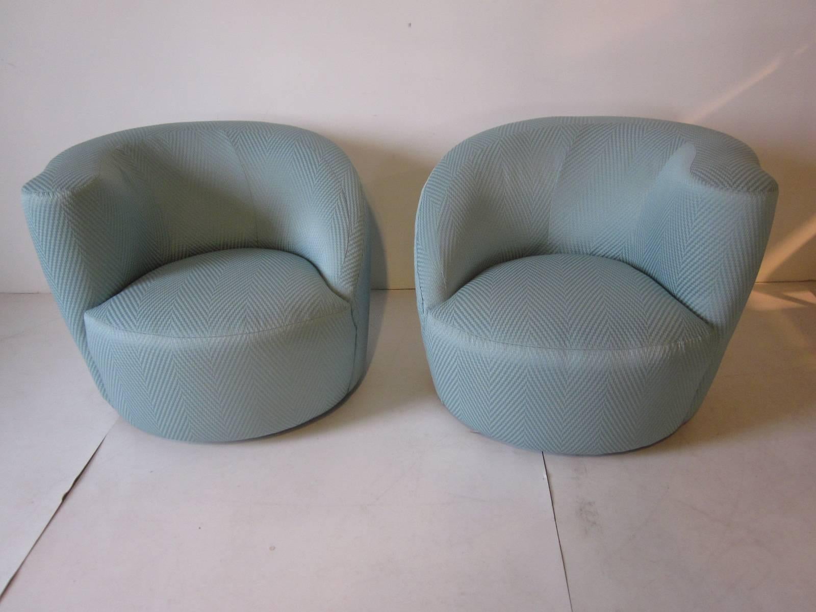 A pair of Kagan swiveling Nautilus club chairs with ottoman, this sculptural chair with the sloping arm and higher arm rest make for a very comfortable seating area especially with the hard to find ottoman.