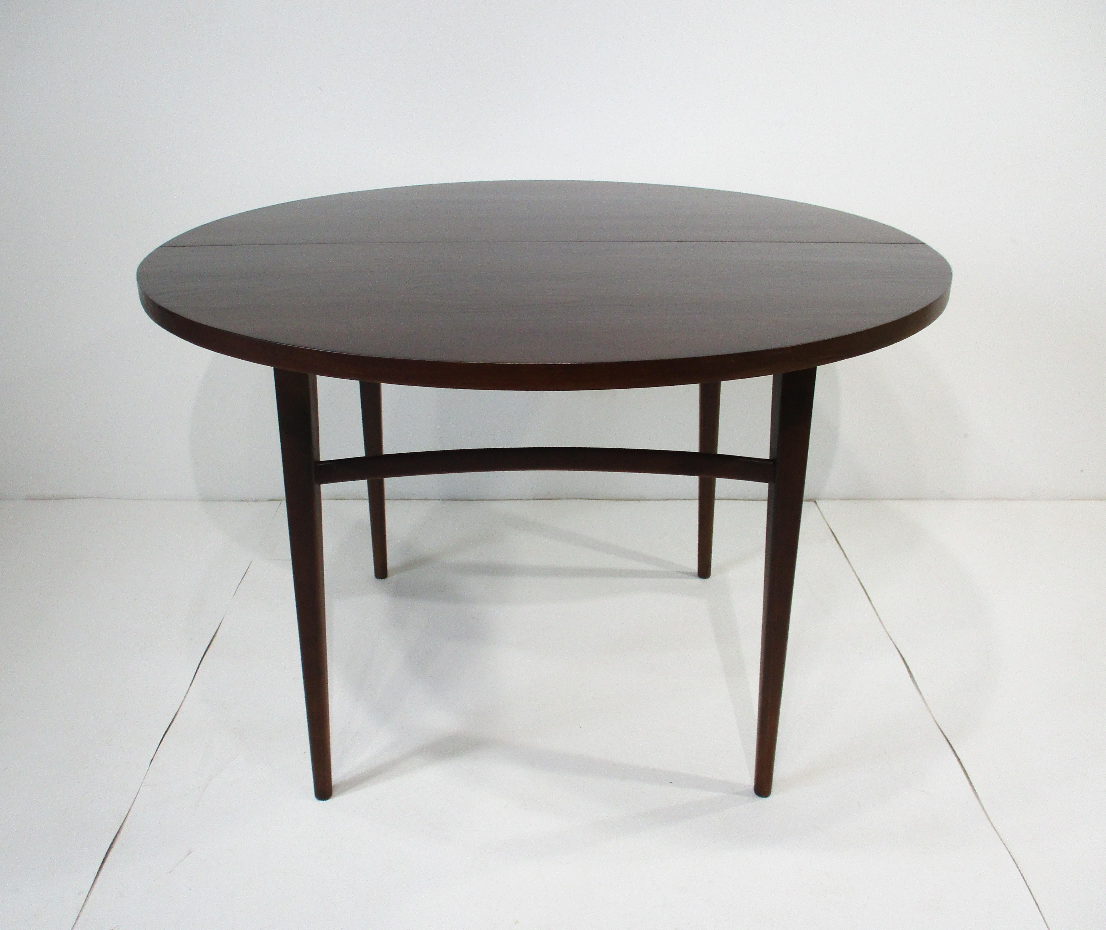A Mid Century dark walnut toned wood dining table with three 14.13