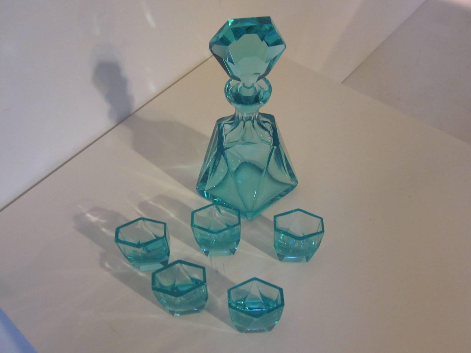A aqua marine colored crystal decanter set with five matching small glasses in the cubist style of Ruba Rombic, the stopper, body and glasses are all cut to a fine standard, heavy with a great feel. The glasses measure 2.25" H x @" L x