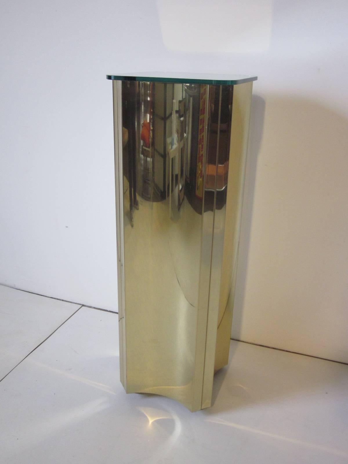 A brass metal sculptural pedestal with mirrored glass top and floating base manufactured by Curtis Jere.