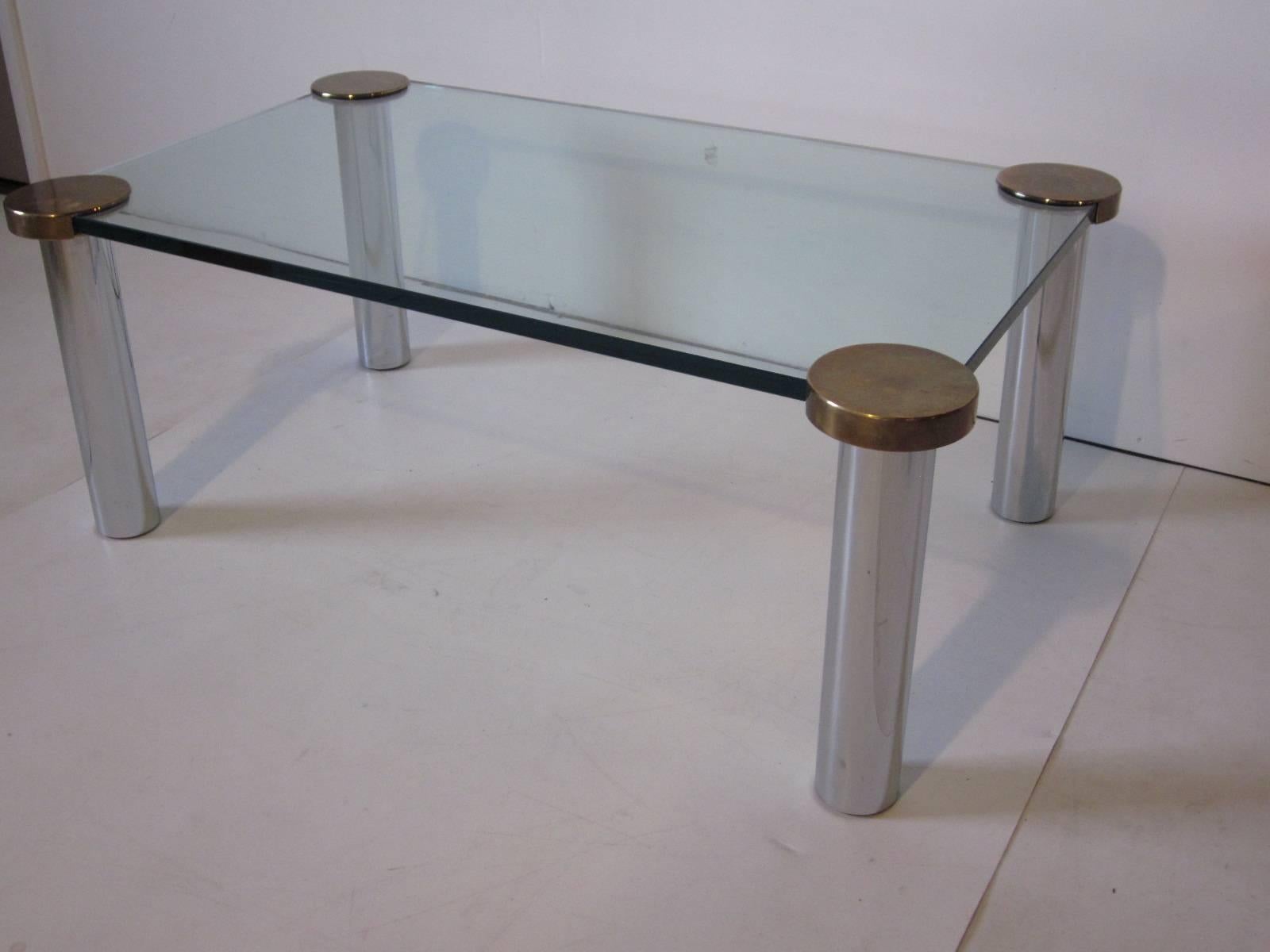 A coffee table in the highest quality with chrome, brass and thick plate glass, rounded upper supports and cylinder legs make up this piece styled in the manner of Leon Rosen for Pace.
