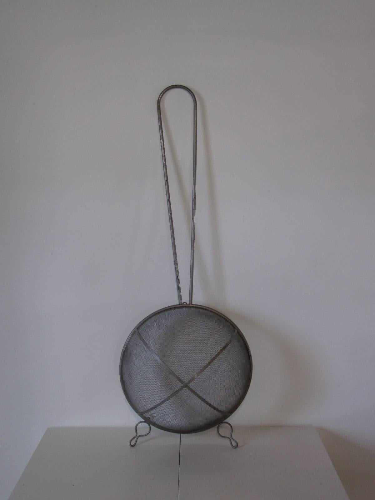 A set of three huge oversized kitchen utensils consisting of a whisk, strainer and a slotted spoon. Welded and formed in metal with a light metal toned paint finish ready to hang in that restaurant or large kitchen. Hanging brackets are attached to
