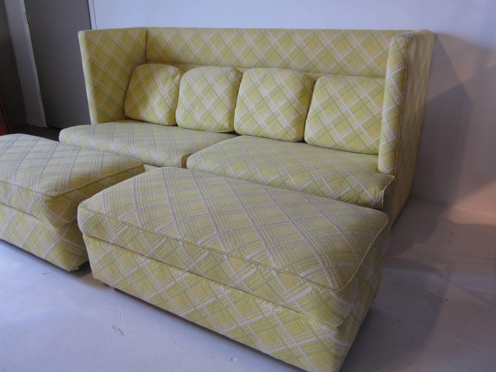 A rare Milo Baughman shelter sofa with four loose back cushions and two matching ottomans on casters. Reupholstered in the past with a celery, off-white and light butter tone in a criss cross pattern . Manufactured by the Thayer Coggin furniture
