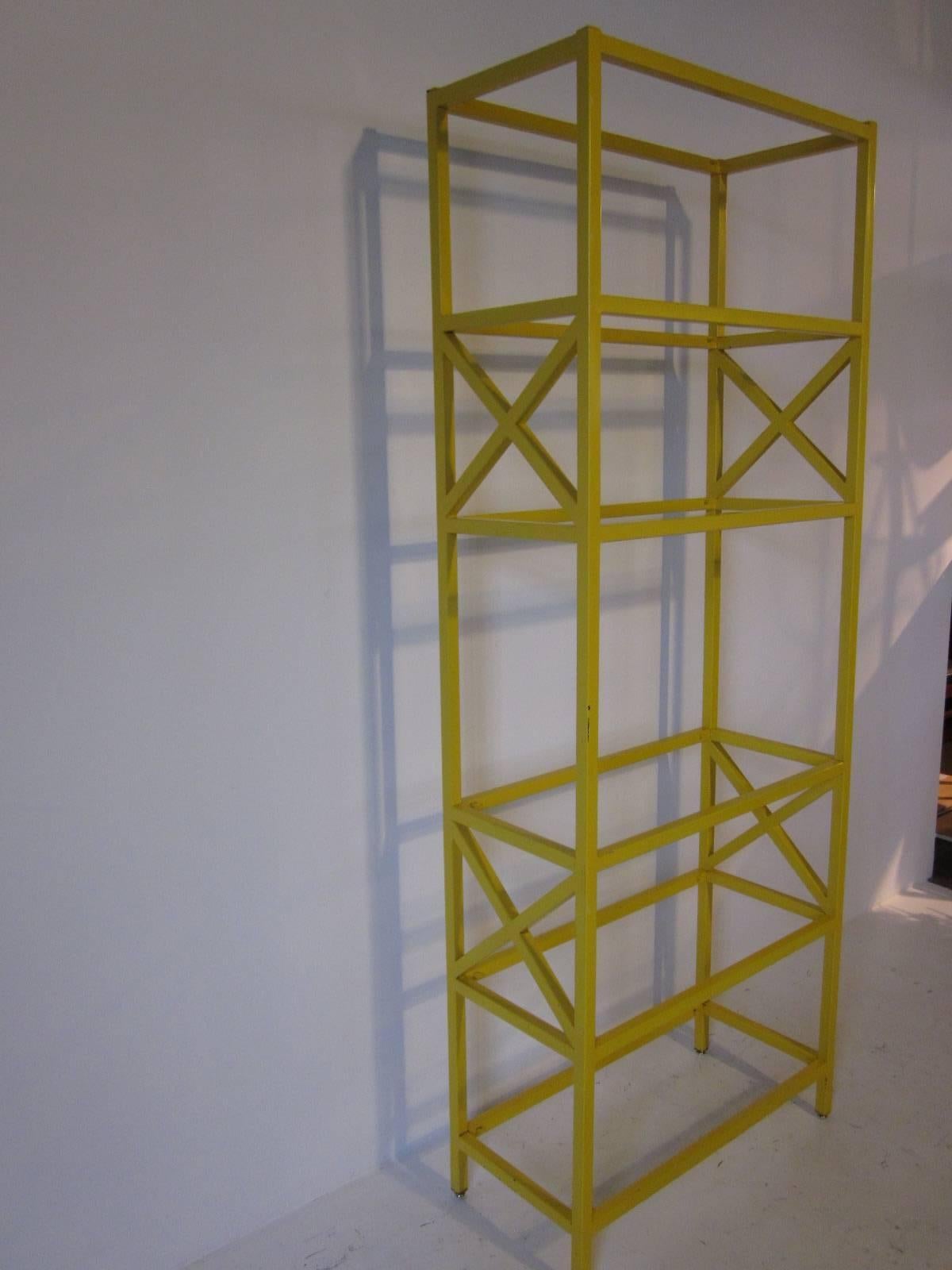 A etagere crafted from square steel tubing and finished in a satin yellow finish consisting of six glass shelves designed in the style of the Baker Furniture Company.