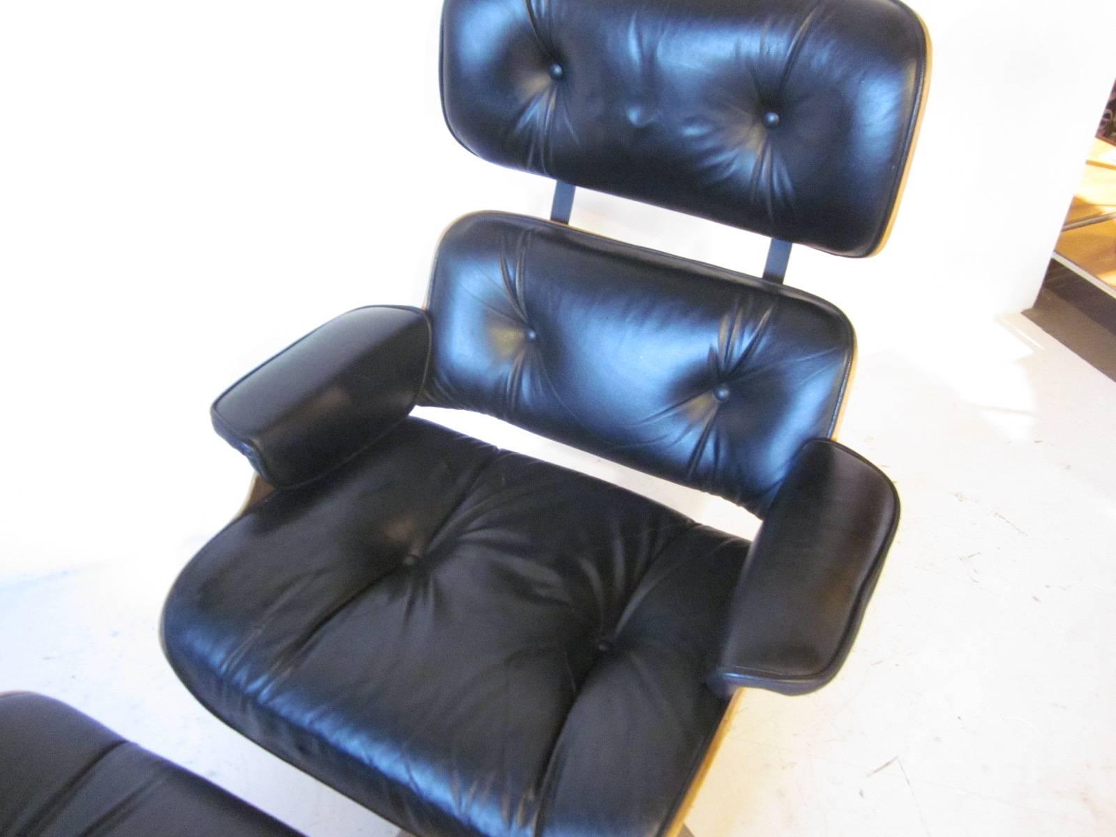 A bent walnut ply lounge chair and matching ottoman with black leather, aluminium base and adjustable spring action for the seating. In the manner of Herman Miller and Ray/Charles Eames. The ottoman size is 25