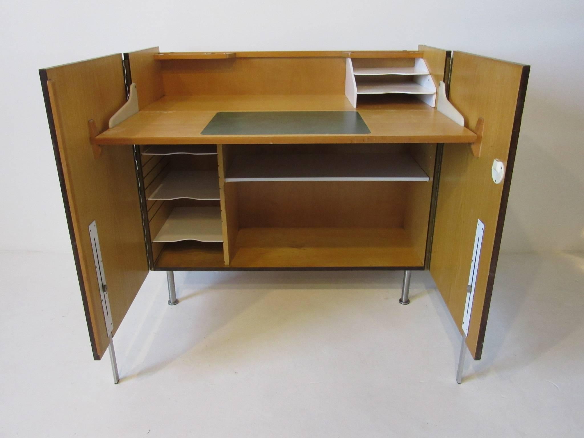 A beautifully grained Brazilian rosewood secretary desk with two doors, the top of the cabinet flips down and turns into a desk. Inside there's a storage area with an adjustable shelve, three adjustable open file shelves, upper pen and pencil trays,