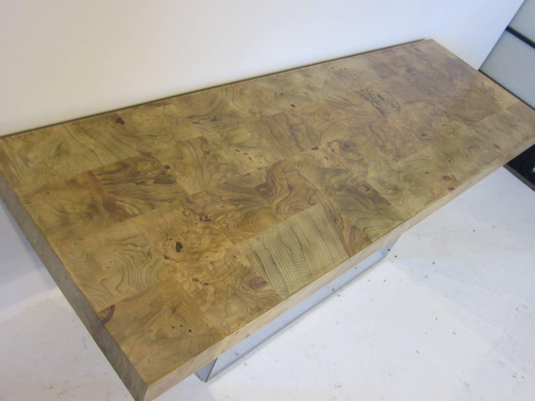 A simple but elegant Milo Baughman olive wood burl topped console table with polished metal base with adjustable feet to the bottom. Manufactured by the Thayer Coggin Furniture Company.