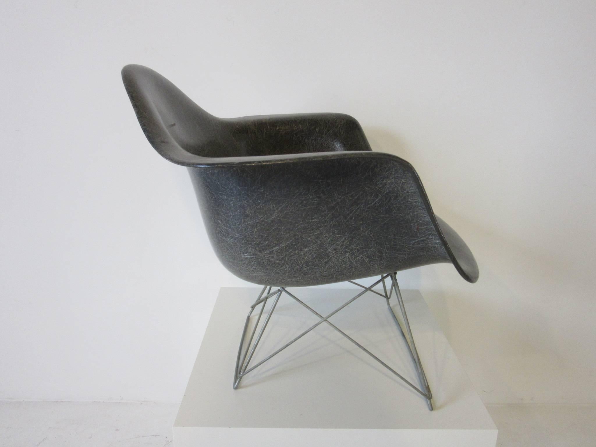 Une très ancienne chaise Eames à bras en fibre de verre gris éléphant avec la base basse en fil de fer en zinc Banner metals et le rare bord en corde. Conserve l'étiquette du fabricant Zenith Plastics Company et le dessin de Herman Miller par