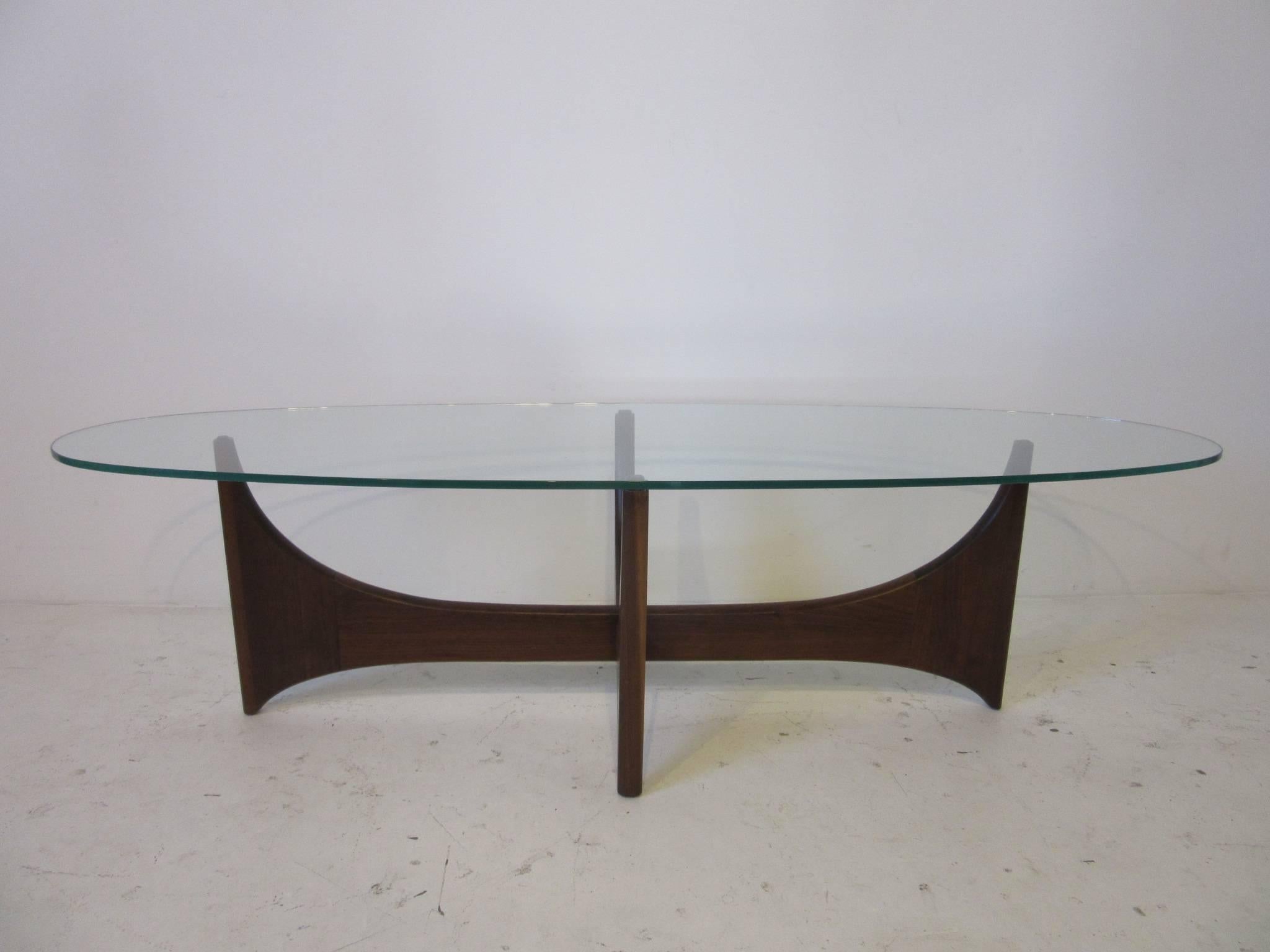 A oval glass topped sculptural dark solid walnut based Adrian Pearsall coffee table manufactured by Craft Associates, a simple and well crafted design.
