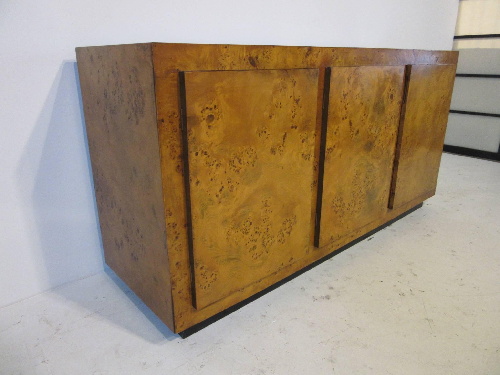 A three-door burl wood credenza with one side holding three drawers and the other two with an adjustable shelve and storage in the manner of Milo Baughman.