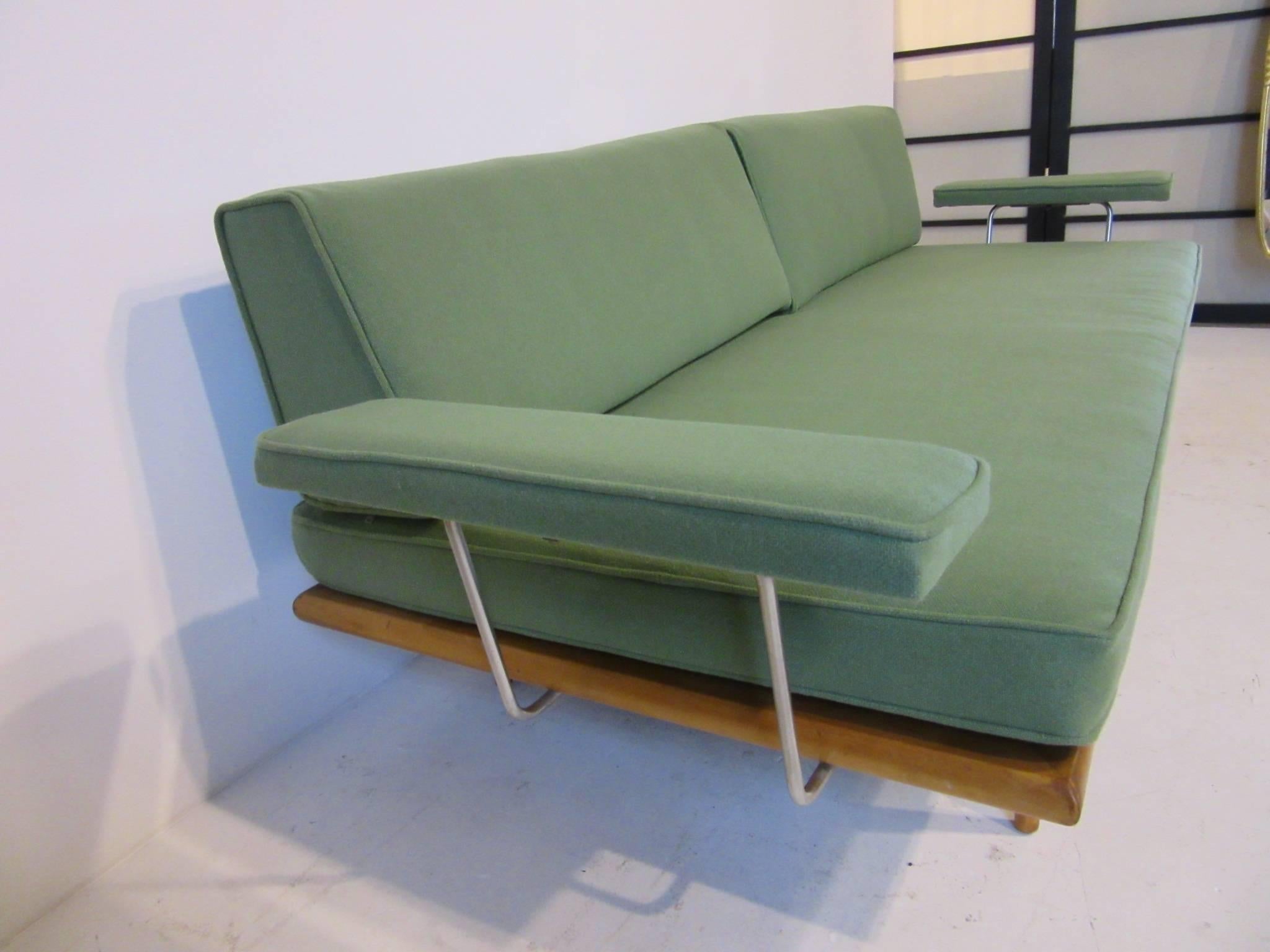 A hard to find Nelson daybed sofa with special order upholstered armrests and maple frame with matching conical legs. Newly reupholstered with period factory Herman Miller sea foam green wool fabric, retains the factory fabric label.